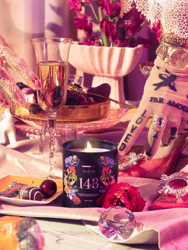 Lit 143 Candle on Opulent and Eclectic Tablescape with Hand Touching Next To Chocolates